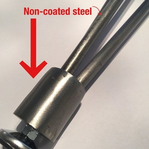 May include: Close-up of a set of three non-coated steel legs for furniture. The legs have adjustable feet with a non-slip bottom.