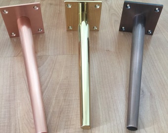 May include: Three metal furniture legs with square plates. The legs are tapered and have a brushed finish. The legs are in the colors copper, gold, and bronze.