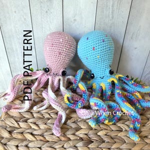 May include: Two crocheted octopus toys with black safety eyes and embroidered mouths. The left octopus is light pink with white speckles, and the right octopus is light blue with multicolored speckles. Text reads PDF PATTERN and On a Whim Crochet.