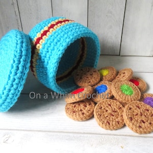 May include: A crocheted cookie jar and cookies. The jar is turquoise with red and yellow stripes. The lid is off, and cookies are spilling out. The cookies are brown with colorful, round decorations. The text "On a Whim Crochet" is visible.