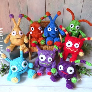 Könnte beinhalten: Eine Sammlung von sieben gehäkelten Monsterpuppen in verschiedenen Formen und Größen, mit großen weißen Augen, Antennen und gestickten Mündern. Der Text PDF PATTERN und On a Whim Crochet ist links und unten rechts zu sehen.