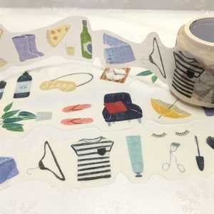 May include: Decorative washi tape roll featuring a repeating pattern of illustrated objects. The pattern includes clothing, accessories, food, and beauty items in soft colors. The tape roll is beige with a white interior.
