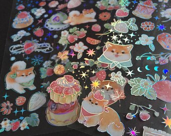 Könnte beinhalten: Eine Bogen mit schimmernden holografischen Aufklebern mit niedlichen Cartoon-Hunden, Erdbeeren, Blumen und Kuchen. Die Aufkleber sind perfekt, um Tagebüchern, Planern und anderen Bastelprojekten einen Hauch von Verspieltheit zu verleihen.