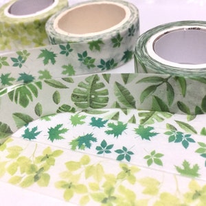 May include: Three rolls of washi tape with green leaf patterns. The tape is translucent and has a white background. The patterns include leaves, flowers, and geometric shapes.