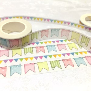 Puede incluir: Dos rollos de cinta washi con un patrón de banderines coloridos. La cinta es blanca con banderines de color azul pastel, rosa, amarillo y verde.