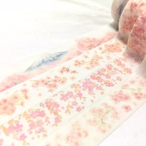 K&ouml;nnte beinhalten: Eine Rolle dekoratives Washi-Tape mit einem zarten Blumenmuster in Rosa- und Wei&szlig;t&ouml;nen. Das Band hat einen dezenten Aquarelleffekt und ein Kirschbl&uuml;tenmuster.