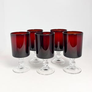 May include: Set of five red wine glasses with clear stems and bases. The glasses are made of glass and have a classic design.