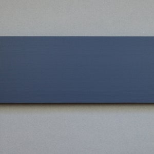 May include: A dark gray rectangular sign with four silver hanging hooks and two black hanging hooks.