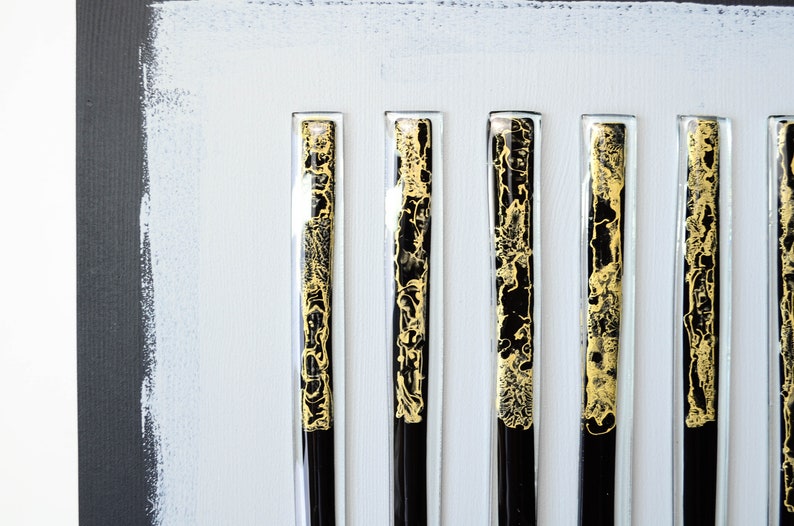 May include: Six black and gold glass panels with a decorative pattern. The panels are mounted on a white background.