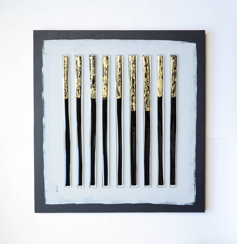 May include: A black and gold abstract wall art piece with 12 vertical glass tubes on a gray background.