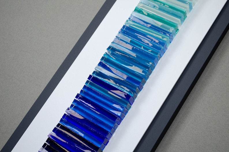 May include: A framed wall art piece featuring a gradient of blue and green glass tiles arranged vertically.