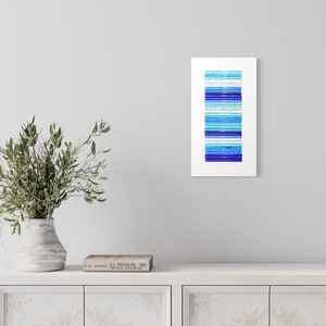 Pu&ograve; includere: Stampa d'arte astratta con una disposizione verticale di strisce blu e turchesi su uno sfondo bianco.