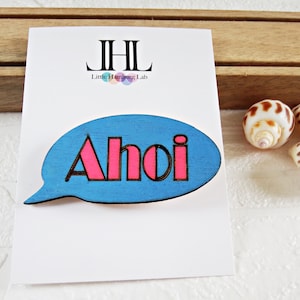 wooden speech bubble brooch AHOI, blue with pink lettering