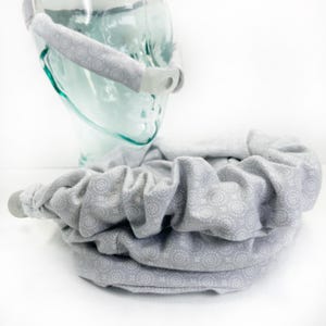 May include: A gray fabric headband with a white swirl pattern. The headband is made of soft, comfortable material and is designed to be worn around the head.