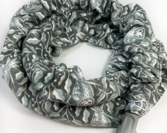 May include: A gray and white patterned CPAP hose cover featuring a repeating design of leaves and owls. The cover is made of soft fabric and has a gray plastic connector at one end. The ResMed logo is visible on the connector.
