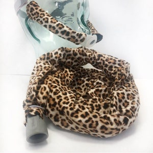 May include: A leopard print fabric cover for a CPAP mask and hose. The cover is made of soft, comfortable fabric and is designed to fit snugly around the mask and hose.