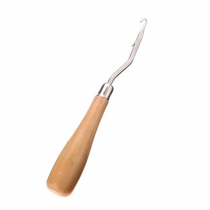 May include: A wooden handled crochet hook with a metal hook.