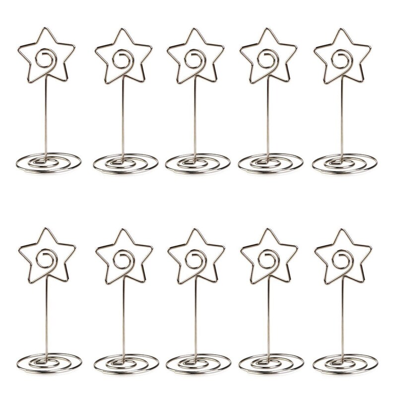 Pode incluir: Dez porta-cart&otilde;es de lugar de metal prateado em forma de estrela. Cada suporte tem uma base em espiral e uma parte superior em forma de estrela.