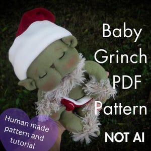 Può includere: Una bambola di stoffa verde con occhi chiusi e guance rosate, che indossa un cappello da Babbo Natale rosso e bianco e un colletto in pelliccia sintetica bianca. Il testo recita: Baby Grinch PDF Pattern, Human made pattern and tutorial, NOT AI.
