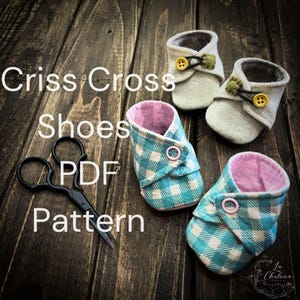 May include: Image of baby shoes in two styles. One style is a light blue and white plaid pattern with a pink interior. The other style is a neutral linen colour with a button and loop closure. The text "Criss Cross Shoes PDF Pattern" is displayed.