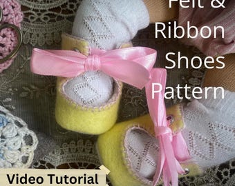 May include: A pair of yellow felt shoes with pink ribbon bows and white lace trim. The shoes are on a lace tablecloth with the text "Felt & Ribbon Shoes Pattern" and "Video Tutorial" visible.