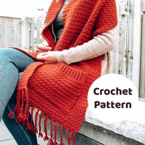 May include: A red crochet scarf with fringe. The scarf is draped over a person's shoulders. The text "Crochet Pattern" is visible in the image.
