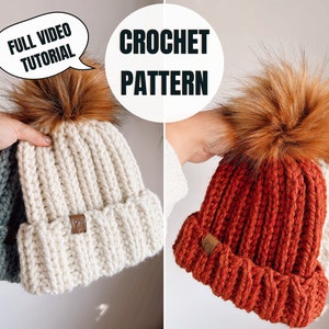 May include: Two crocheted beanies with faux fur pom poms. One beanie is white and the other is rust colored. Both beanies have a ribbed texture. The text "FULL VIDEO TUTORIAL" is in a speech bubble above the white beanie. The text "CROCHET PATTERN" is above the rust colored beanie.