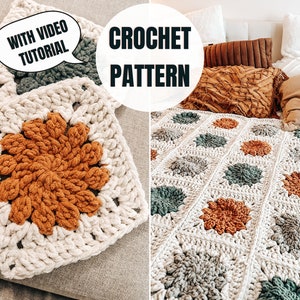May include: A crochet blanket with a floral pattern in shades of brown, green, and white. The blanket is made of chunky yarn and has a textured look. The image includes the text "CROCHET PATTERN" and "WITH VIDEO TUTORIAL".