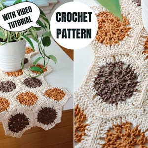 May include: A crocheted table runner with a honeycomb design in cream, brown, and orange. The text "CROCHET PATTERN" is displayed. A speech bubble says "WITH VIDEO TUTORIAL". The runner is placed on a white table with plants.