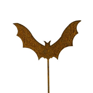 May include: A rusty brown metal bat silhouette with a long stem. The bat is a Halloween decoration.