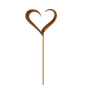 May include: A garden stake featuring a heart-shaped top with a textured, weathered brown rust finish. The heart is formed by two curved metal pieces that meet at the bottom, attached to a long, straight, thin metal rod extending downward.