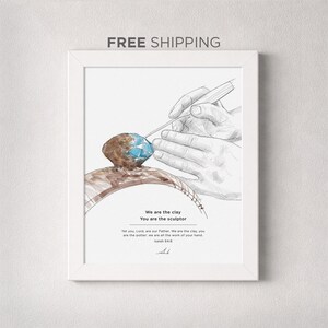 May include: White framed art print showing a sketch of hands sculpting a ring with a blue gem. The text reads "We are the clay, You are the sculptor" and "Isaiah 64:8".