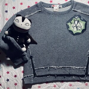 Kid’s upcycled- Jack Skellington patch and buttons added to a Rag doll & Lockits brand sweater, size 5 (gently worn).