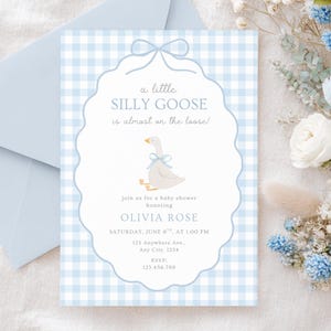 Puede incluir: Una invitaci&oacute;n a un baby shower con un fondo de cuadros vichy azul claro. La invitaci&oacute;n presenta una ilustraci&oacute;n de un ganso con un lazo azul. El texto incluye "a little SILLY GOOSE is almost on the loose!" y detalles del evento.