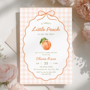 May include: Baby shower invitation with a peach theme. The invitation has a peach-coloured gingham background and a scalloped border. The text "A Sweet Little Peach Is On The Way!" is displayed, along with event details, including the date, time, and location.