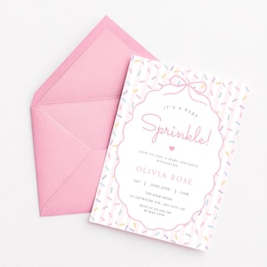 Op de afbeelding: Een roze baby sprinkle uitnodiging met bijpassende envelop. De uitnodiging bevat de tekst "It's a Baby Sprinkle!" in een decoratief lettertype, samen met evenementdetails. Het ontwerp bevat een strooiselpatroon en een strik.
