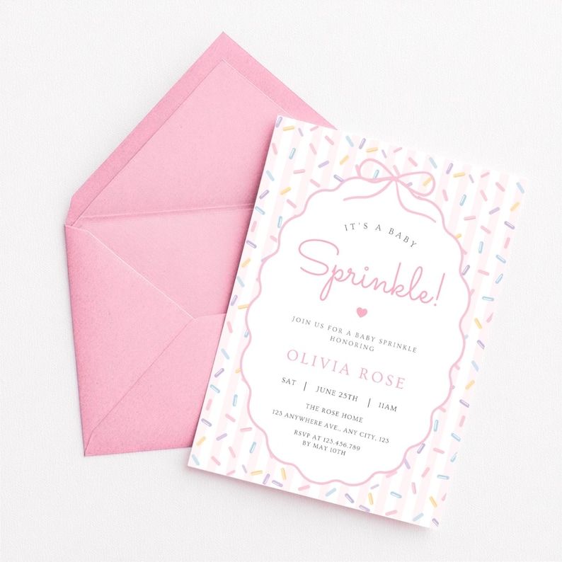 Op de afbeelding: Een roze baby sprinkle uitnodiging met bijpassende envelop. De uitnodiging bevat de tekst "It's a Baby Sprinkle!" in een decoratief lettertype, samen met evenementdetails. Het ontwerp bevat een strooiselpatroon en een strik.