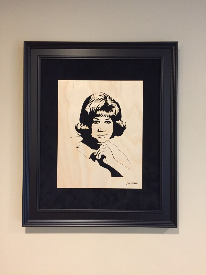 Op de afbeelding: Zwart-wit silhouet portret van een vrouw met kort haar, ingelijst in een zwart frame met een zwarte passe-partout.