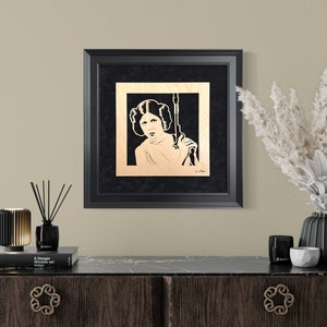 Carrie Fisher as Princess Leia Blaster at the Ready portrait is hand cut using a scroll saw and mounted to a black suede mat and framed image 1