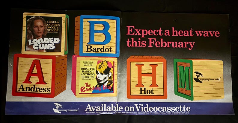 May include: Vintage movie advertisement featuring wooden blocks spelling out "ABH" and "M". The blocks display movie titles and actors, including "Loaded Guns" and "The Ravishing". The text "Expect a heat wave this February" is also visible.