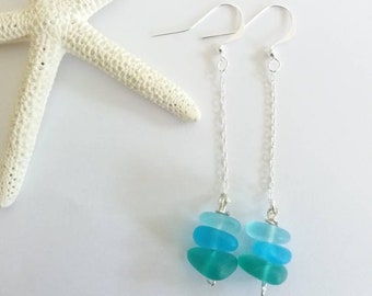 May include: A pair of silver dangle earrings with three graduated turquoise sea glass beads on each earring.