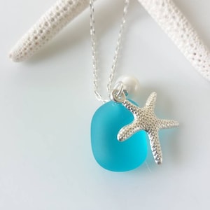 May include: A turquoise sea glass pendant necklace with a silver starfish charm and a white pearl accent.