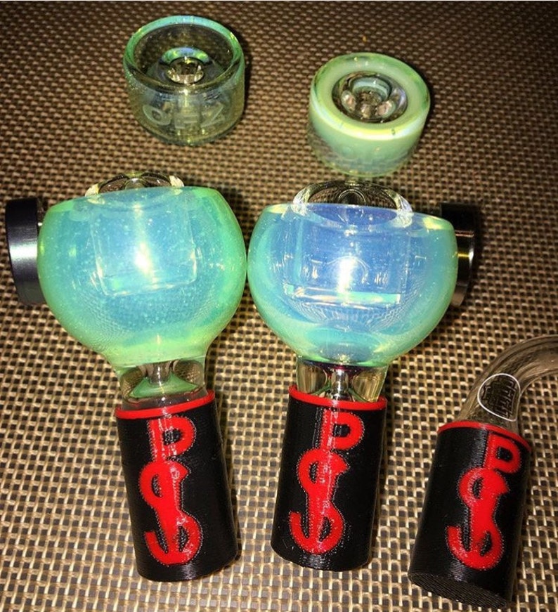 May include: A collection of glass smoking accessories. The set includes several clear glass bowls and a curved glass tube. The bowls have a blue and green iridescent finish. The bases are black with a red dollar sign design.