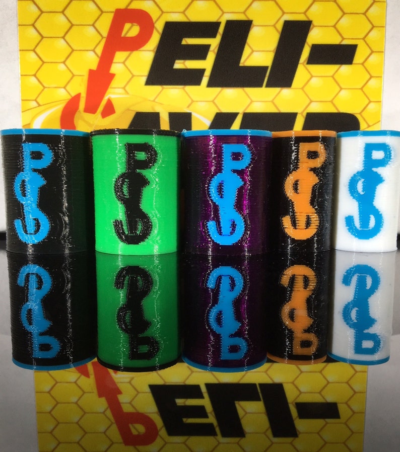 May include: A collection of cylindrical objects in various colors, including black, green, purple, orange, and white. Each cylinder features a contrasting blue or black "Peli-Saver" logo. The background displays a yellow honeycomb pattern with the text "Peli-Saver".