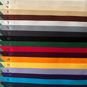 Op de afbeelding: Eenentwintig stofstalen in verschillende kleuren, genummerd van 1 tot en met 21. De stalen zijn verticaal gerangschikt, met de nummers links van elk staal.