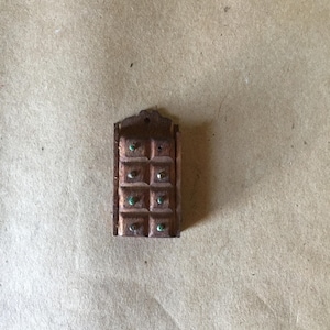 May include: A small wooden box with a hinged lid and nine compartments. Each compartment has a small green jewel-like stone in the center.