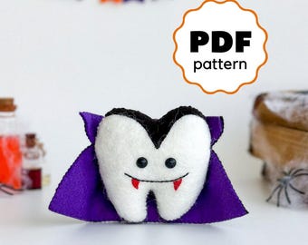 May include: PDF pattern for a felt vampire tooth plush toy. The tooth is white with a black cape and red fangs. The toy has a cute, smiling face.