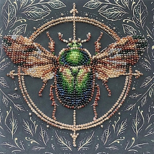 Può includere: Un'opera d'arte a perline raffigurante un coleottero dettagliato con accenti verdi, marroni e blu. L'insetto è centrato all'interno di una cornice circolare color oro, su uno sfondo scuro con motivi a foglie dorate. L'opera mostra un'intricata lavorazione a perline.