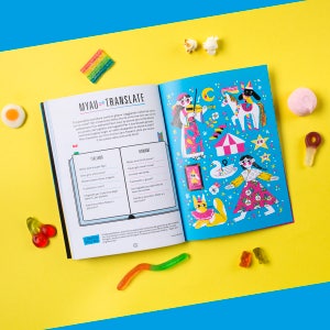 May include: An open book with a blue cover and colourful illustrations. The book is titled "MYAU = TRANSLATE" and features a bilingual dictionary with Italian and Romanian words. The book is open to a page with a section titled "ITALIANO" and another section titled "ROMANĂ".