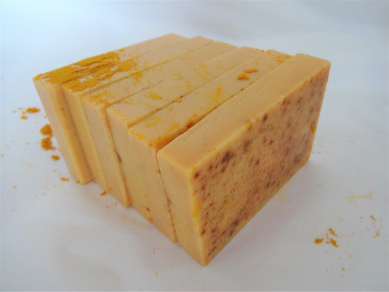 Puede incluir: Una pila de seis barras rectangulares de jab&oacute;n hecho a mano. El jab&oacute;n es de color amarillo claro con una textura moteada. El jab&oacute;n est&aacute; dispuesto en forma de pir&aacute;mide.